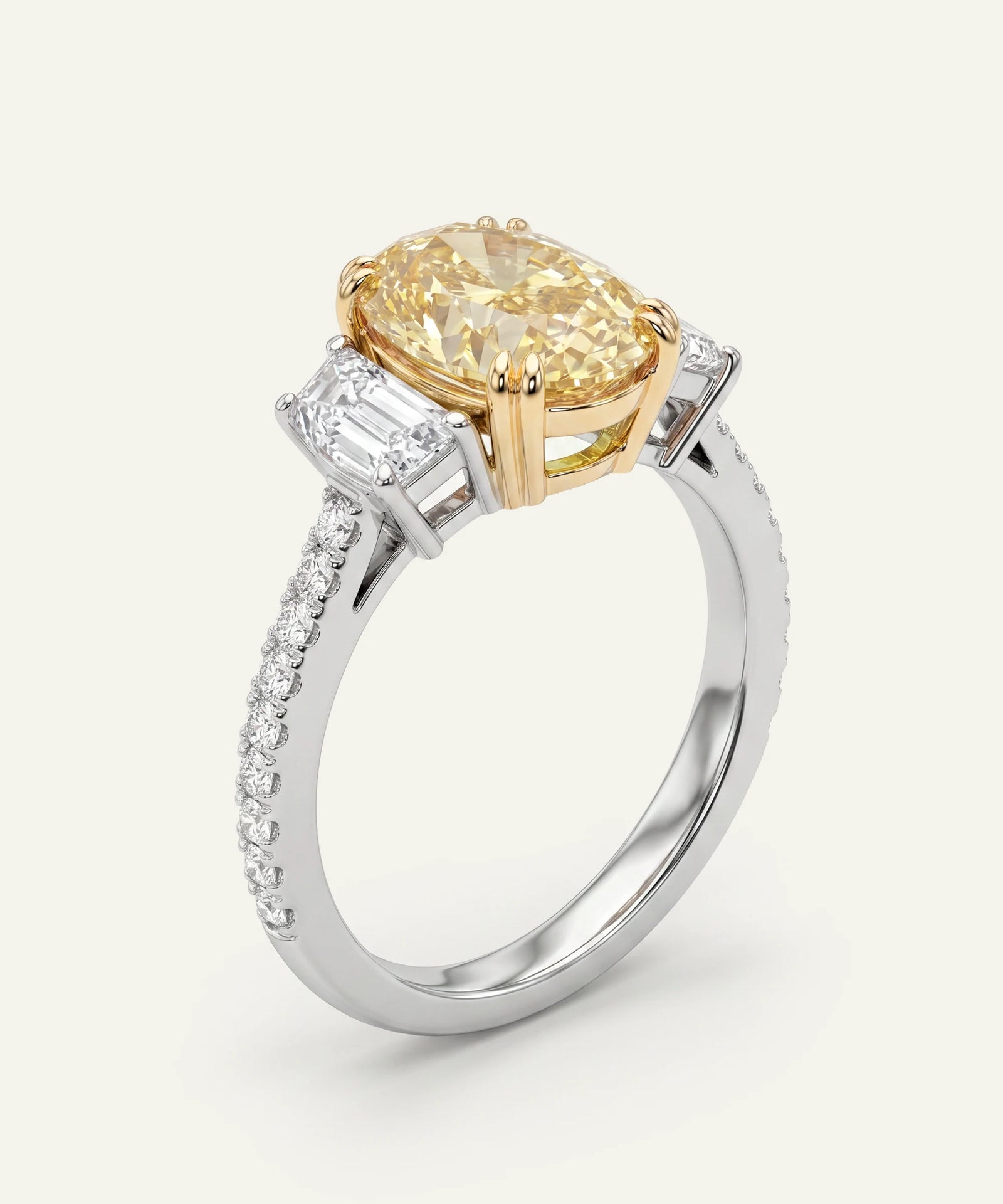 Gold and silver ring with a yellow gemstone on a white background
