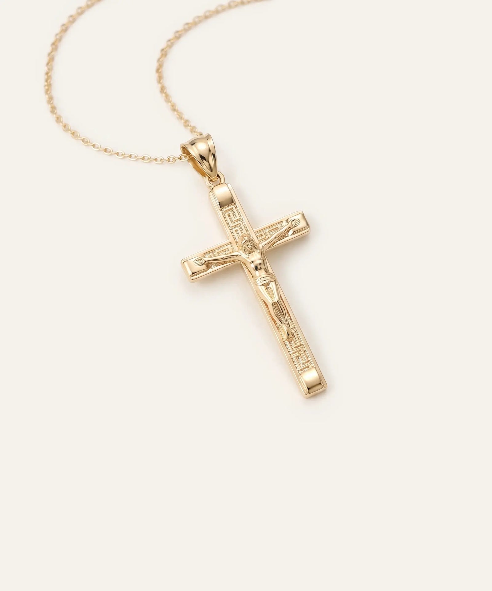 Gold cross pendant on a chain against a white background