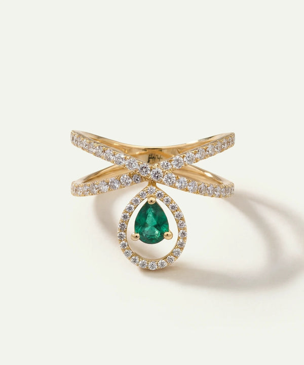 Gold ring with a green gemstone on a light beige background