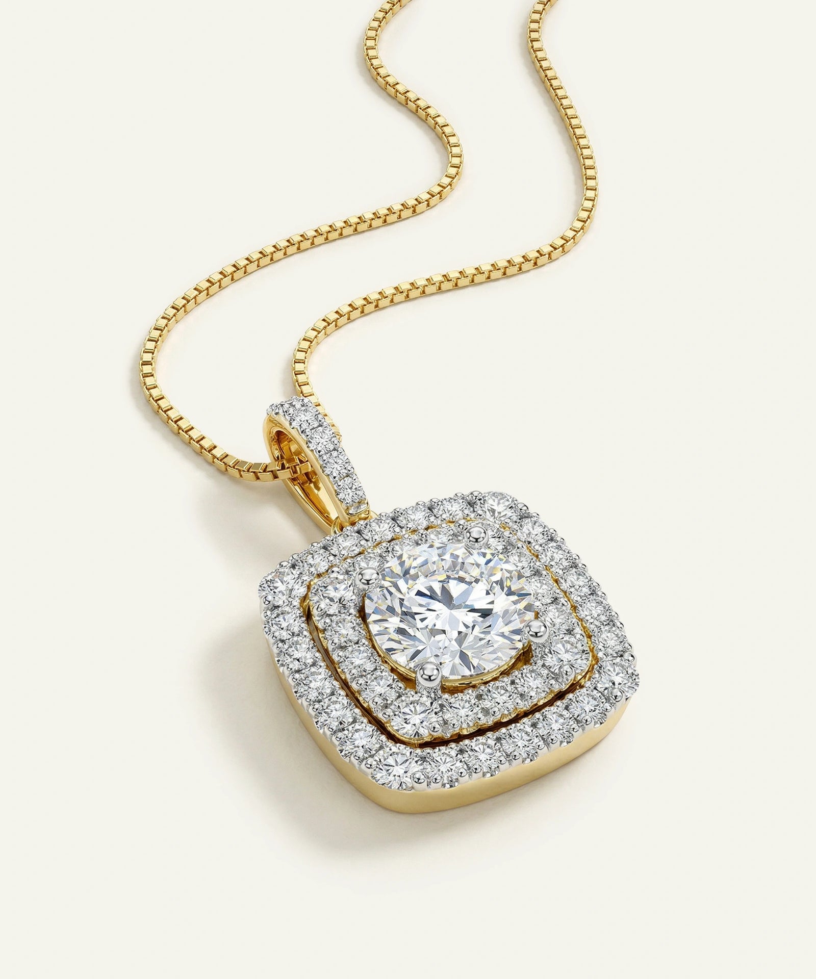 Gold necklace with a diamond pendant on a light background