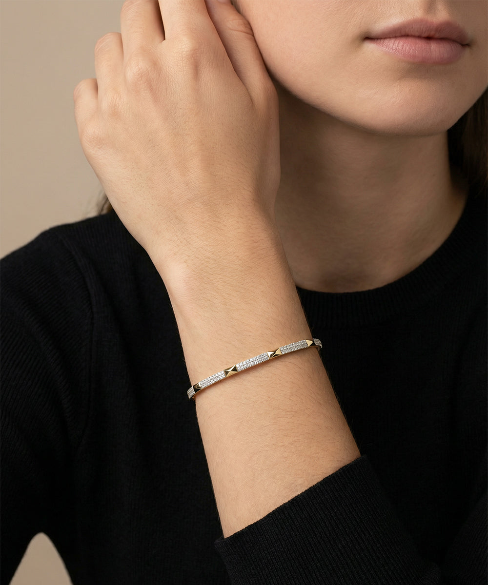 Person wearing a delicate bracelet on a neutral background