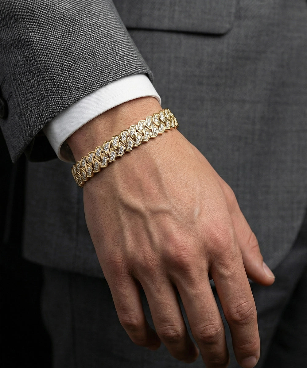 Gold bracelet on a person's wrist with a gray suit background