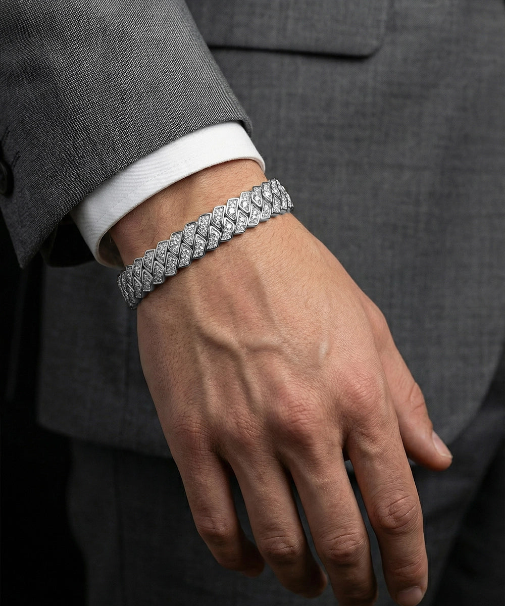 Hand wearing a silver bracelet with a dark suit background