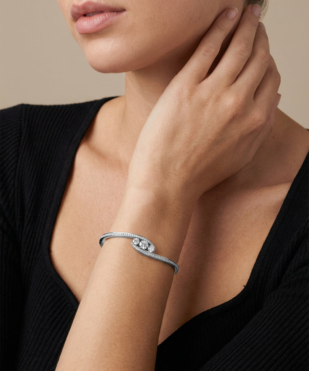Silver bracelet on a wrist with a neutral background
