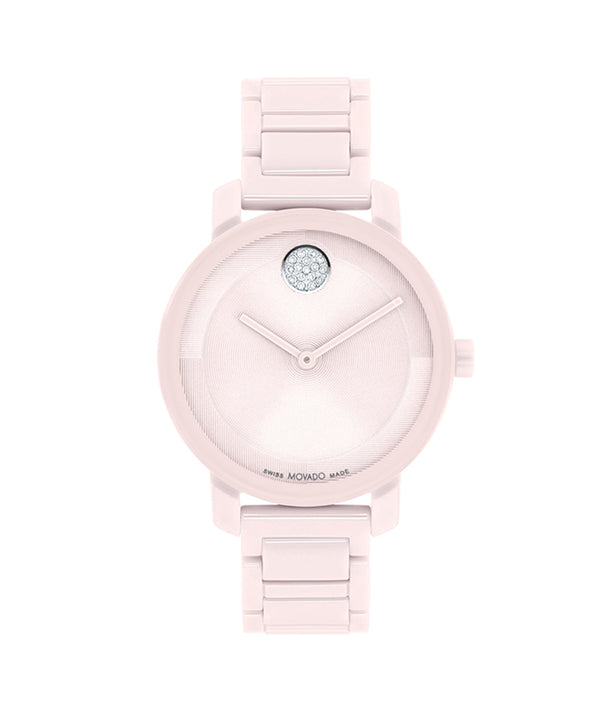 Pink watch with a gemstone on the face against a white background