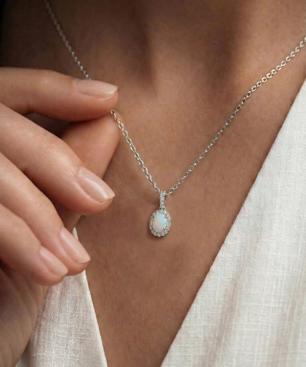 Close-up of a silver necklace with a pendant worn by a person.