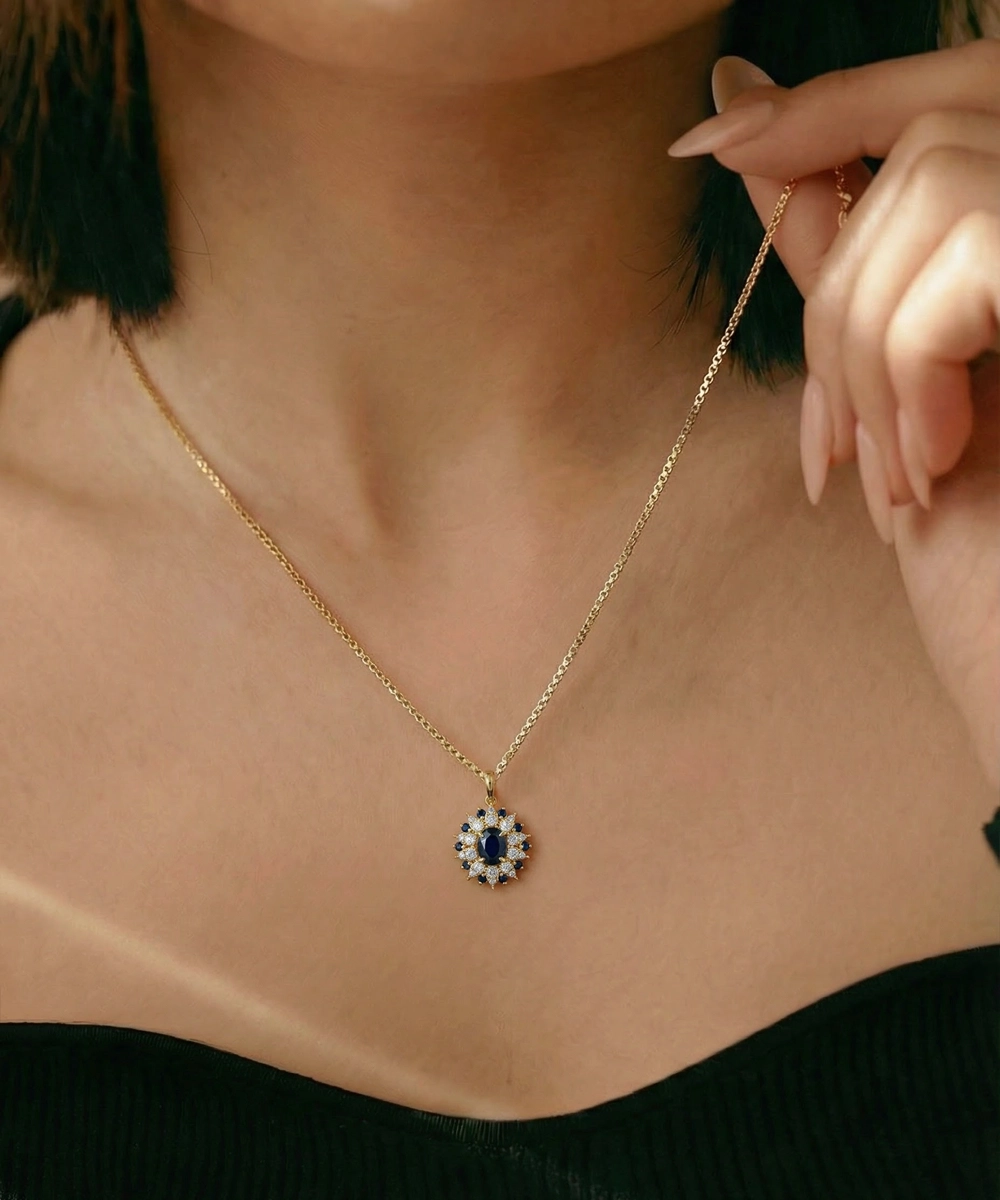 Close-up of a person wearing a gold necklace with a blue and white pendant.