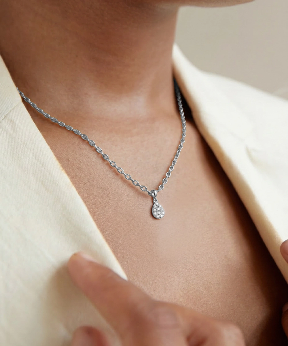 Silver necklace with a pendant worn by a person, with a blurred background