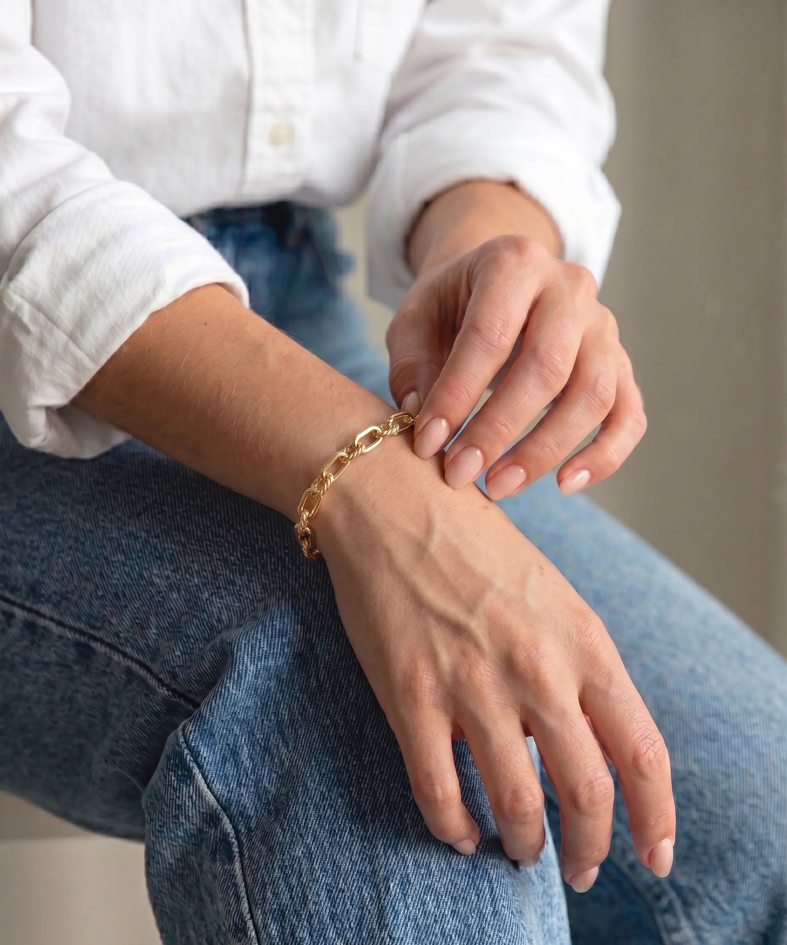Person wearing a gold bracelet on a casual setting