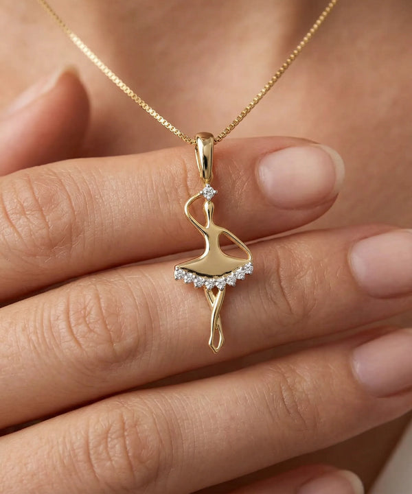 Gold ballerina pendant necklace on a hand