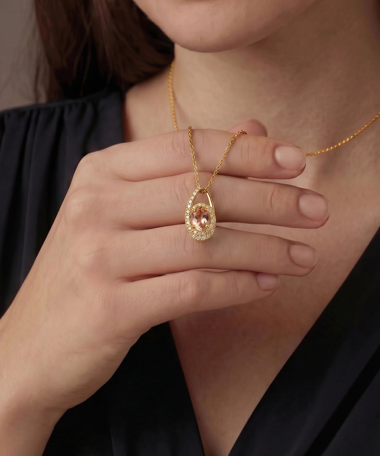 Gold necklace with a pendant worn by a person