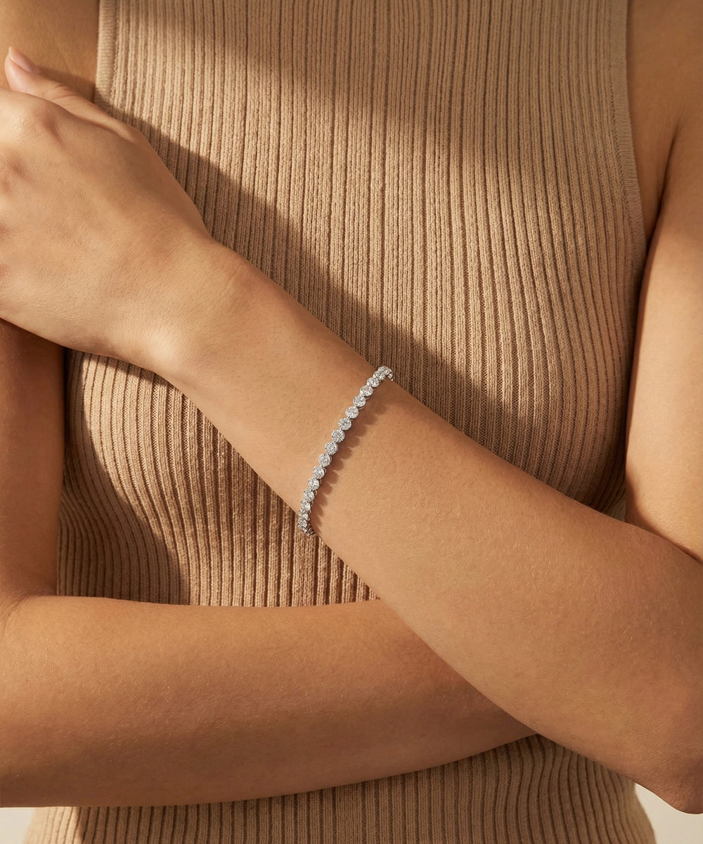 Silver bracelet on a person's wrist with a neutral background