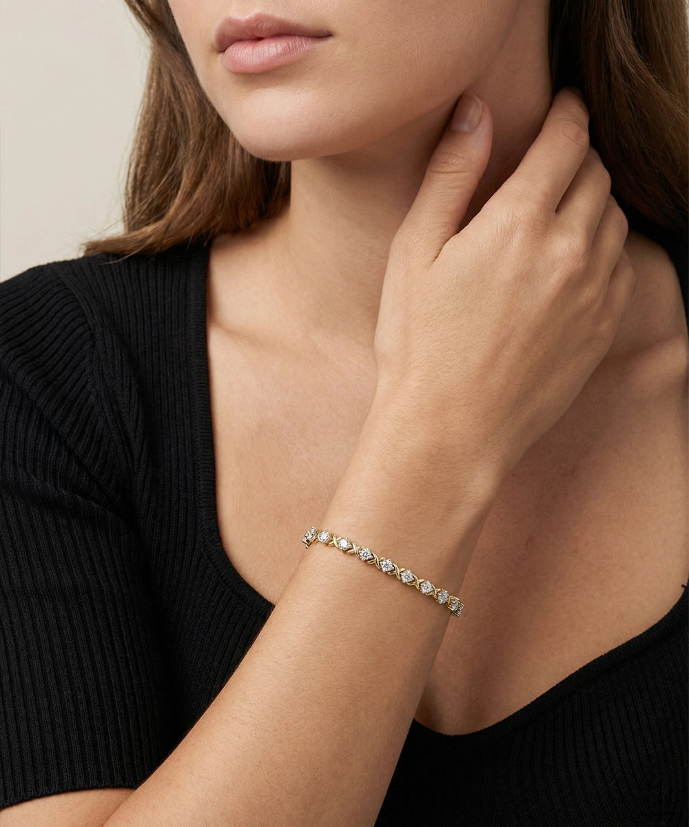 Woman wearing a diamond bracelet on her wrist with a neutral background