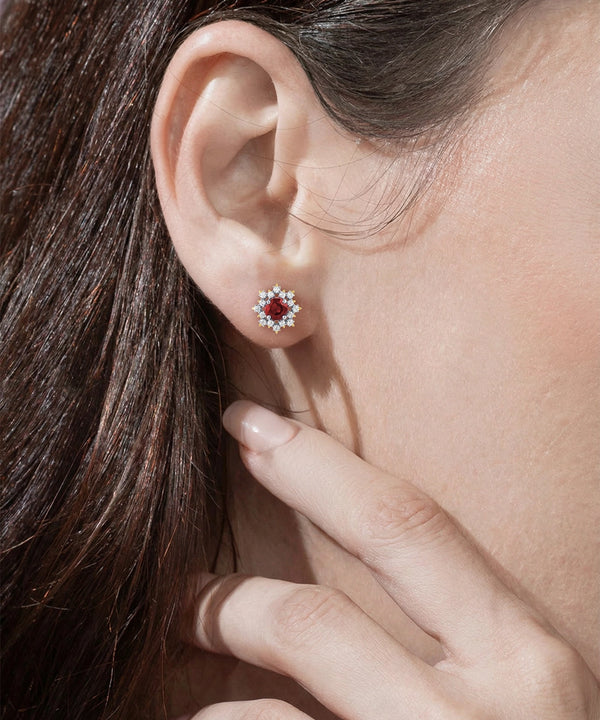 Close-up of a person wearing a red and silver earring.