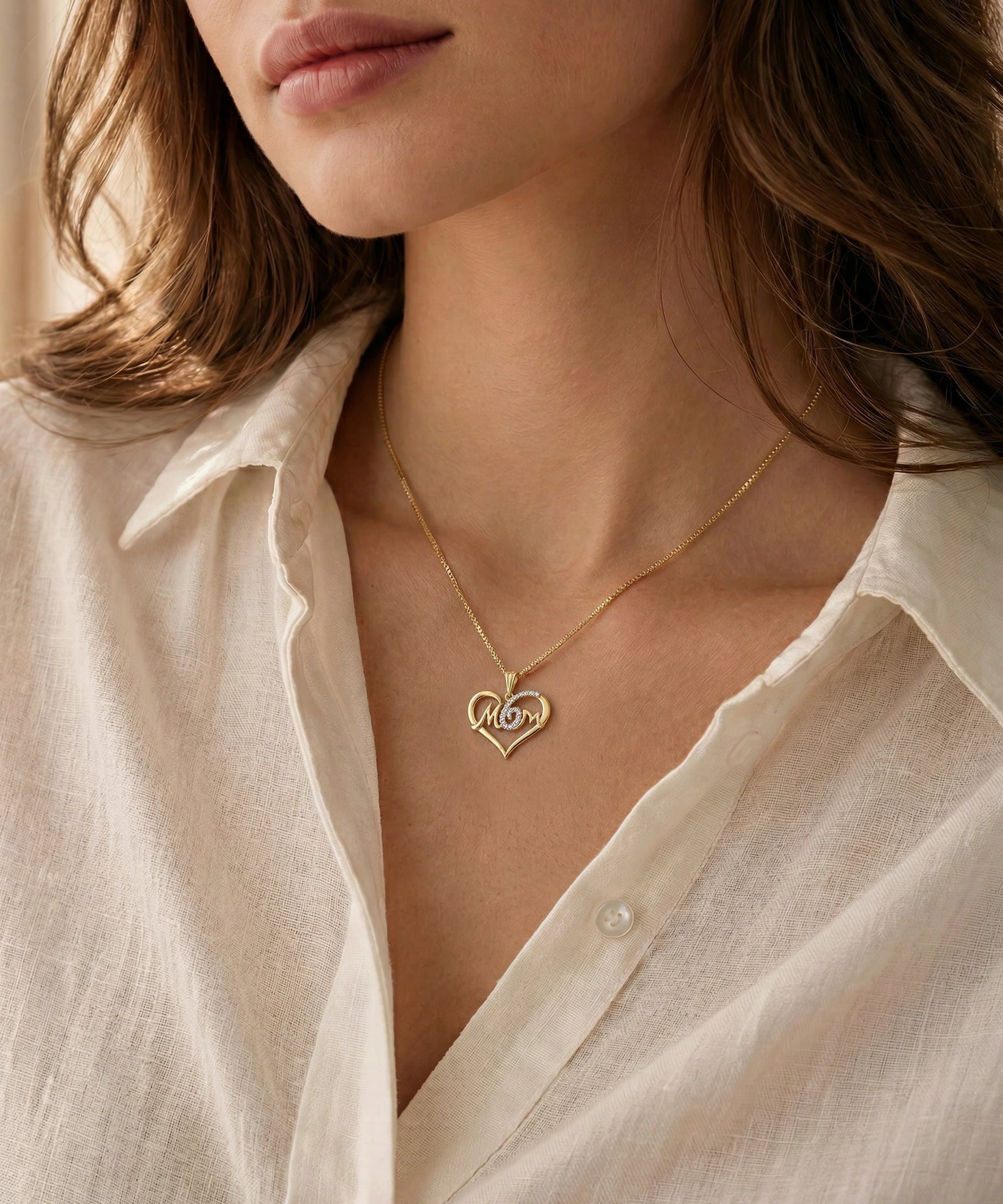 Close-up of a person wearing a delicate gold necklace with heart-shaped pendants.