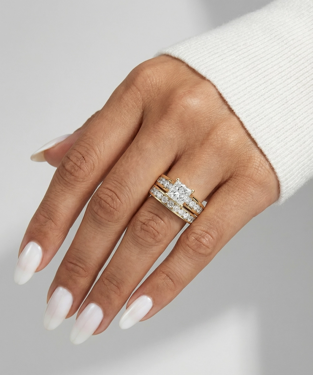 Hand wearing a diamond ring on a neutral background