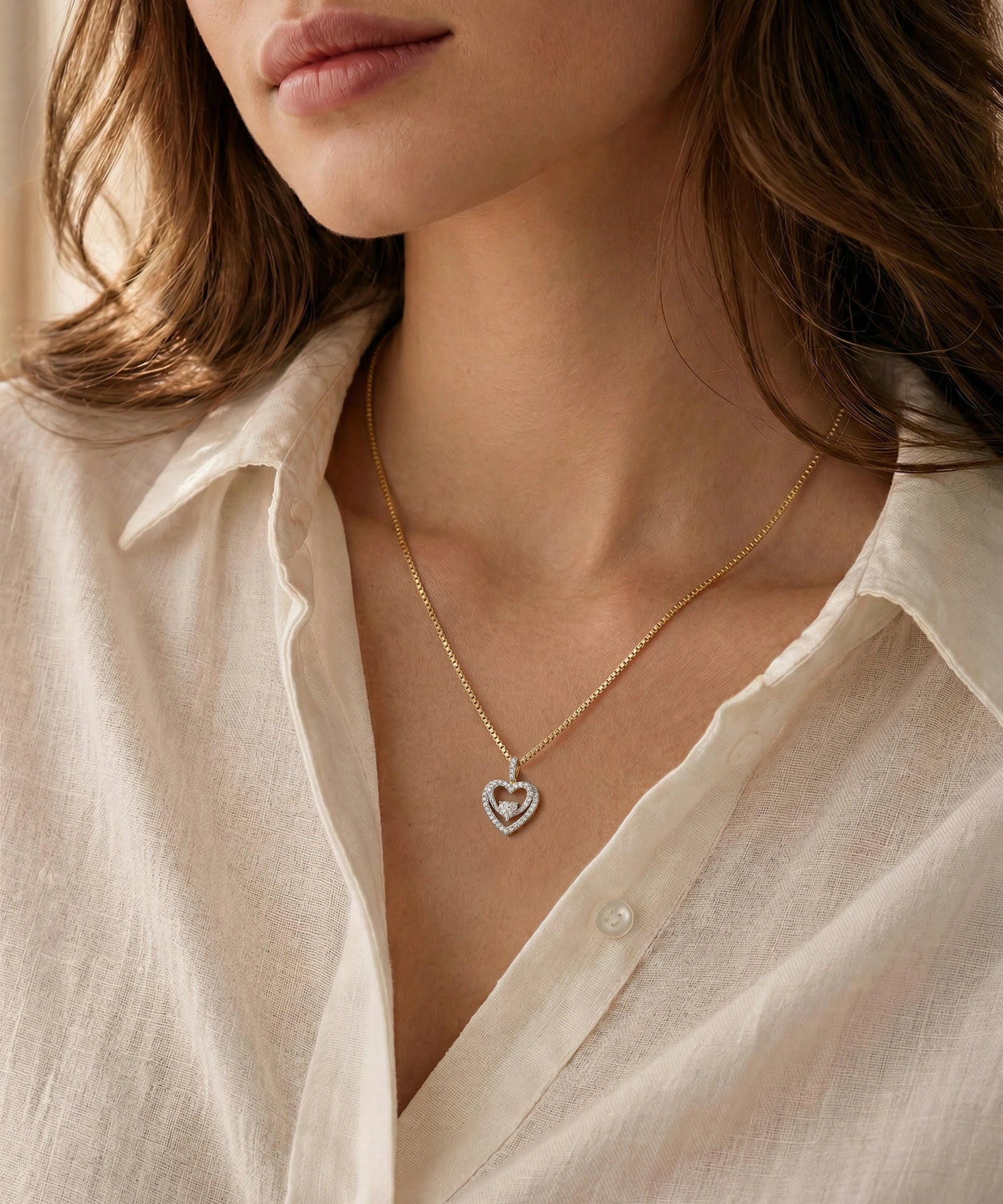 Necklace with a heart pendant worn by a person in a light-colored shirt.