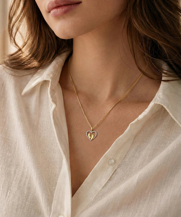 Close-up of a person wearing a delicate necklace with a plain background