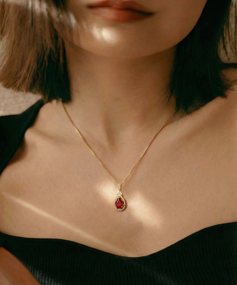 Gold necklace with a red pendant worn by a person