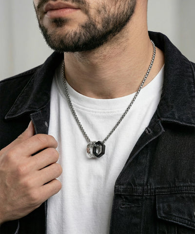 Man wearing a black jacket, white shirt, and silver necklace with a pendant. - alternate view