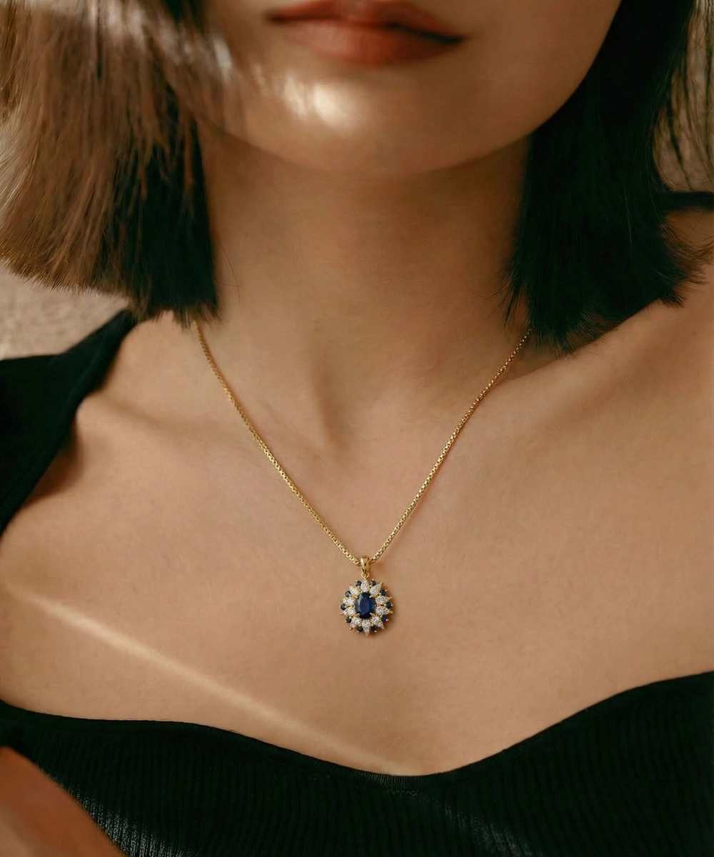 Close-up of a person wearing a gold necklace with a pendant featuring blue stones.