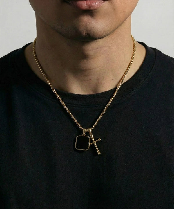 Men's gold chain necklace with a black square pendant and gold cross pendant.