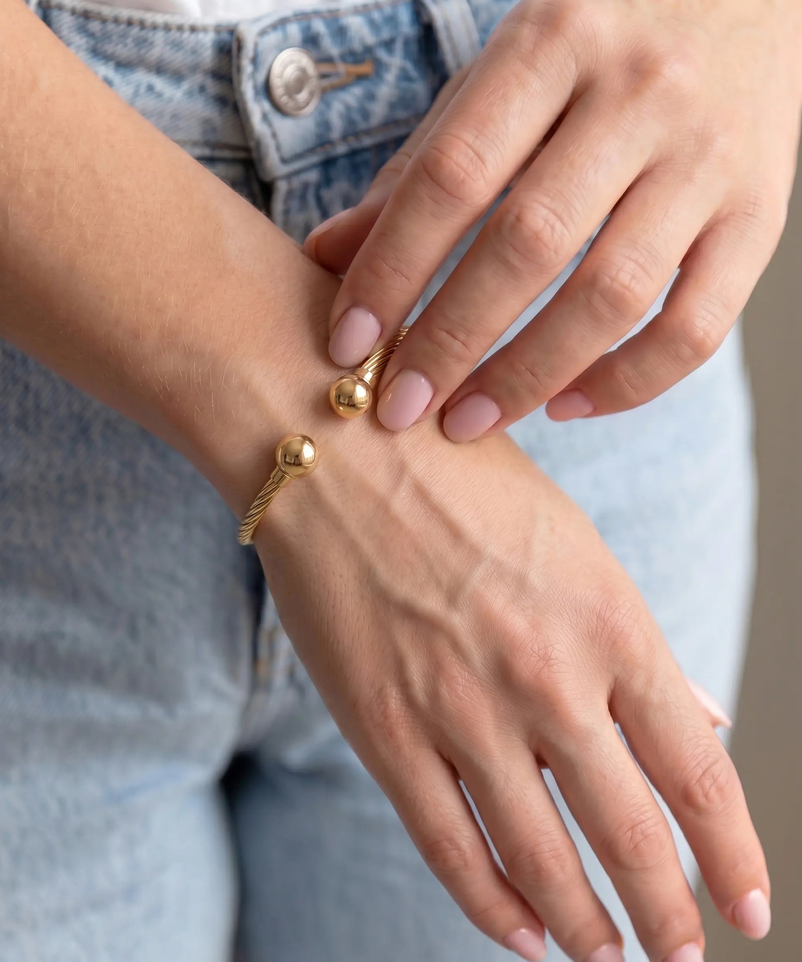 Gold bracelet on a wrist with a blurred background
