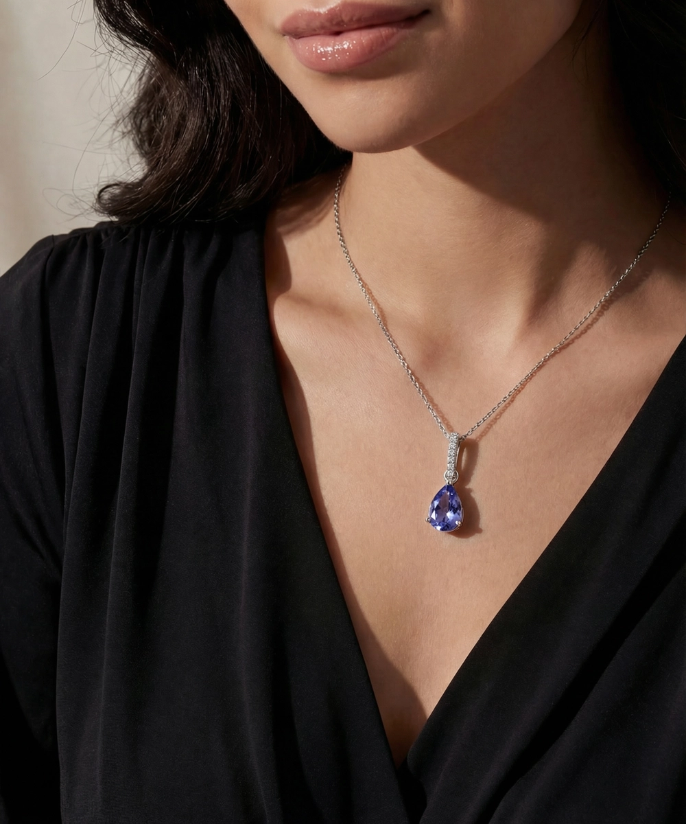Woman wearing a necklace with a blue teardrop pendant