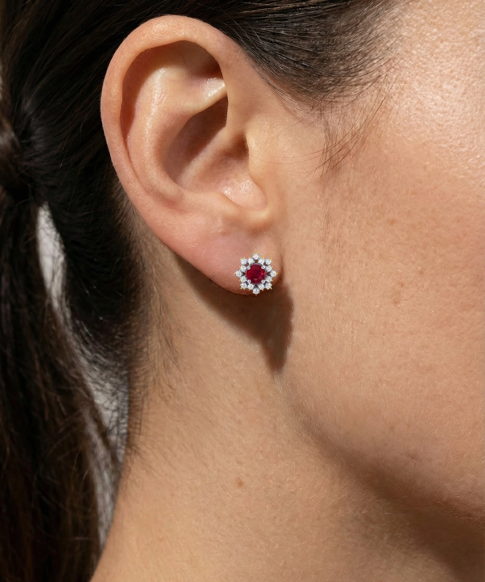 Close-up of an ear wearing a floral stud earring with a blurred background