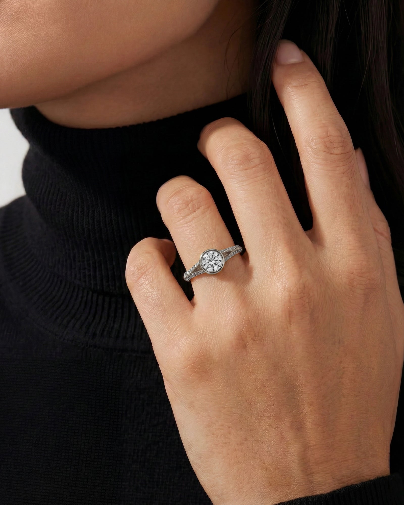Close-up of a hand wearing a diamond ring with a blurred background