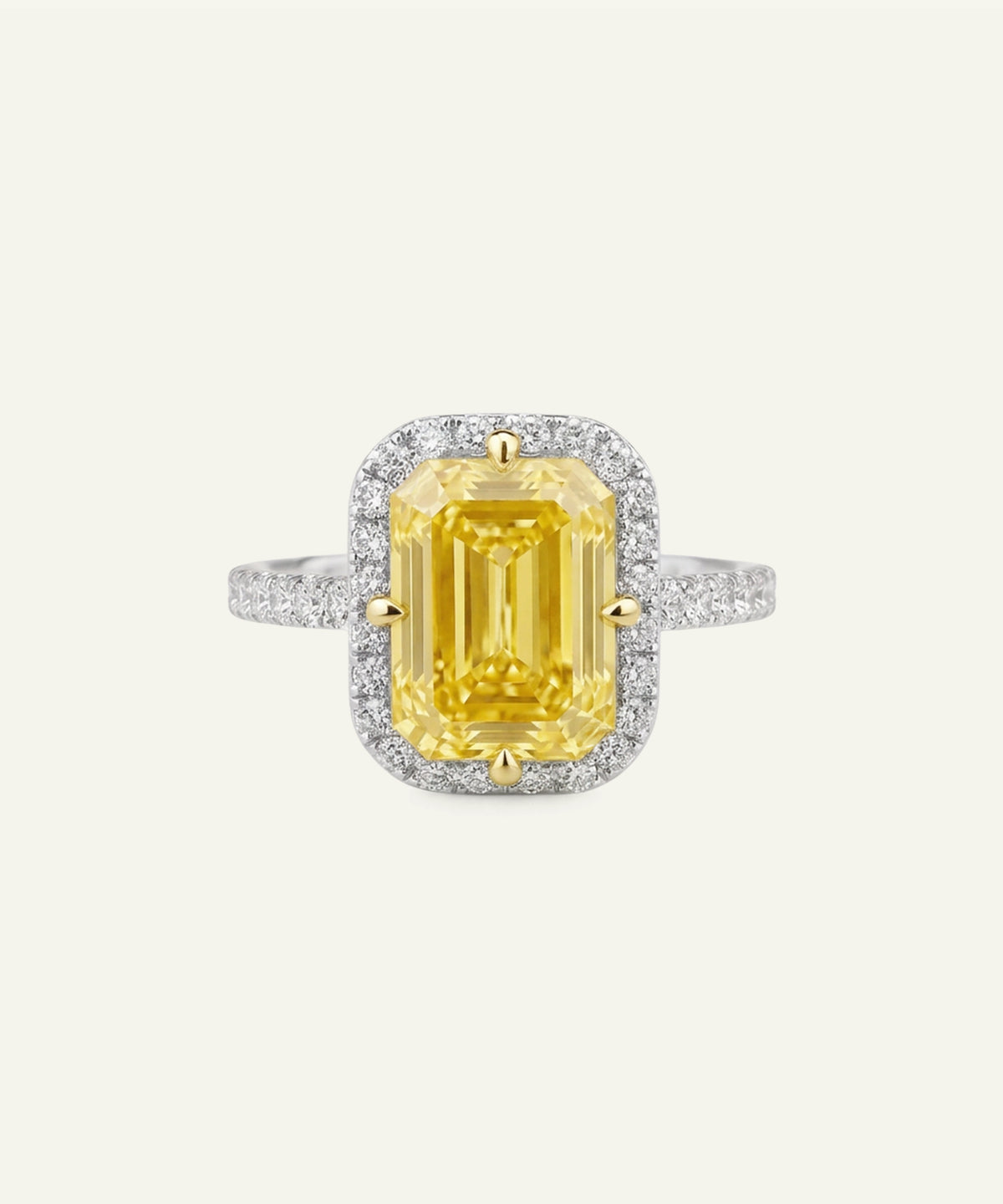 A yellow emerald-cut halo ring featuring a large center stone surrounded by a double halo of small clear stones, with a yellow-gold four-prong setting and a white-metal band accented with pavé diamonds, shown on a light cream background.