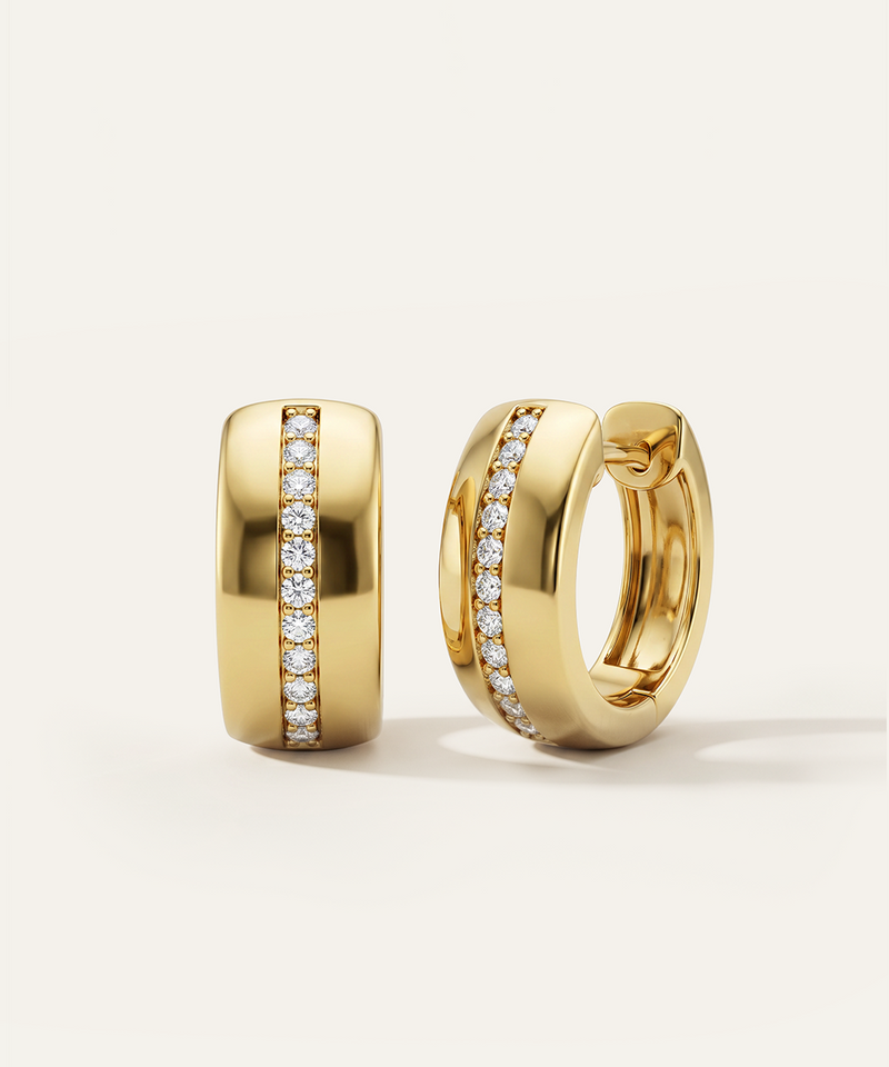 Gold hoop earrings with diamond accents on a light beige background