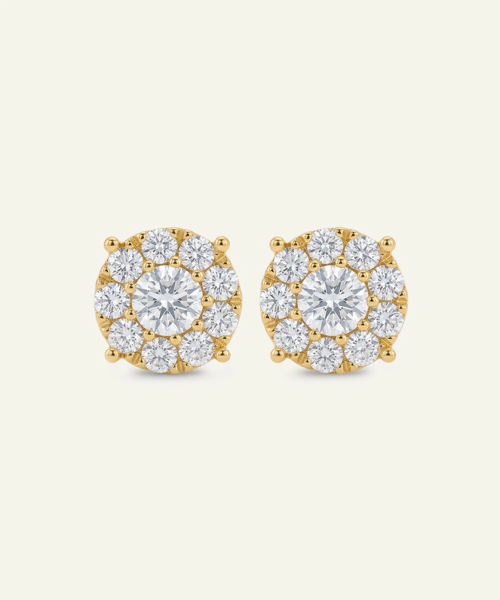 Gold earrings with clear gemstones on a white background