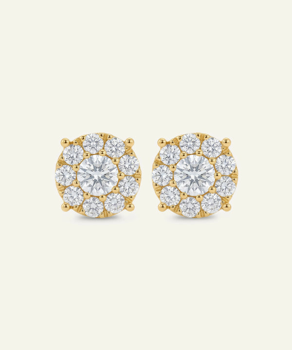 Gold earrings with clear gemstones on a white background