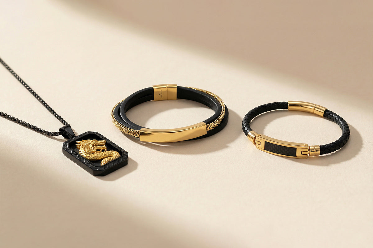 Gold and black jewelry set including a pendant, two bracelets, and a necklace on a beige background