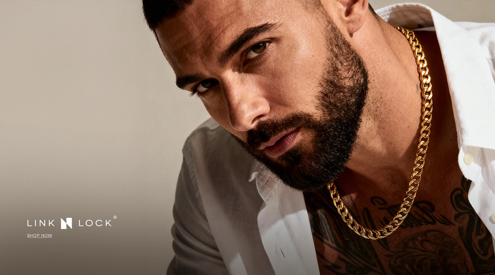 Man wearing a gold chain with a neutral background
