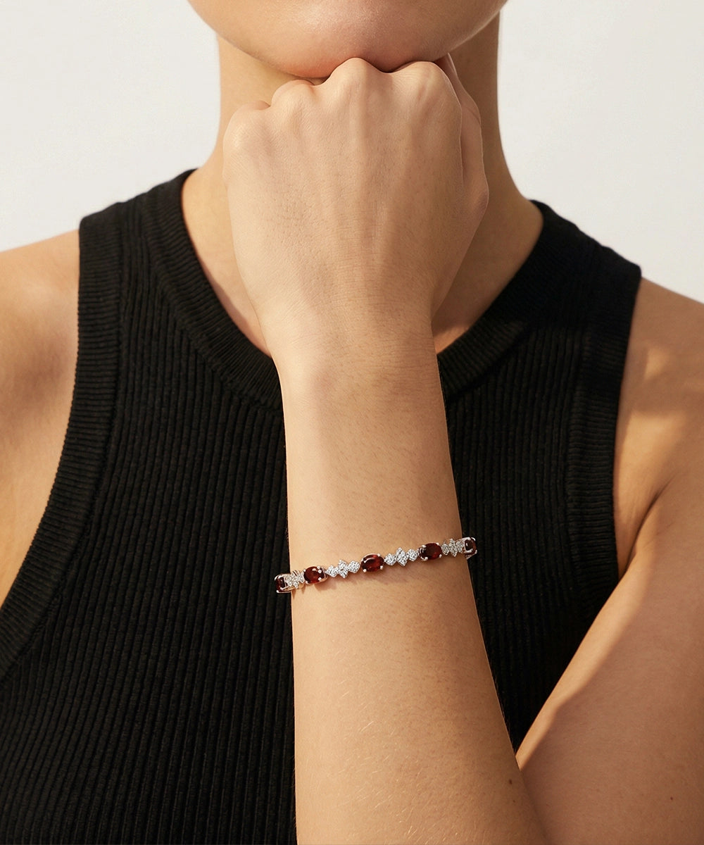 Person wearing a bracelet with beads on a plain background