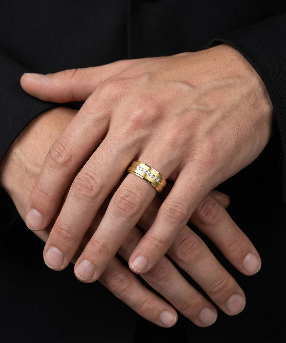 Close-up of a hand wearing a gold ring with a black background