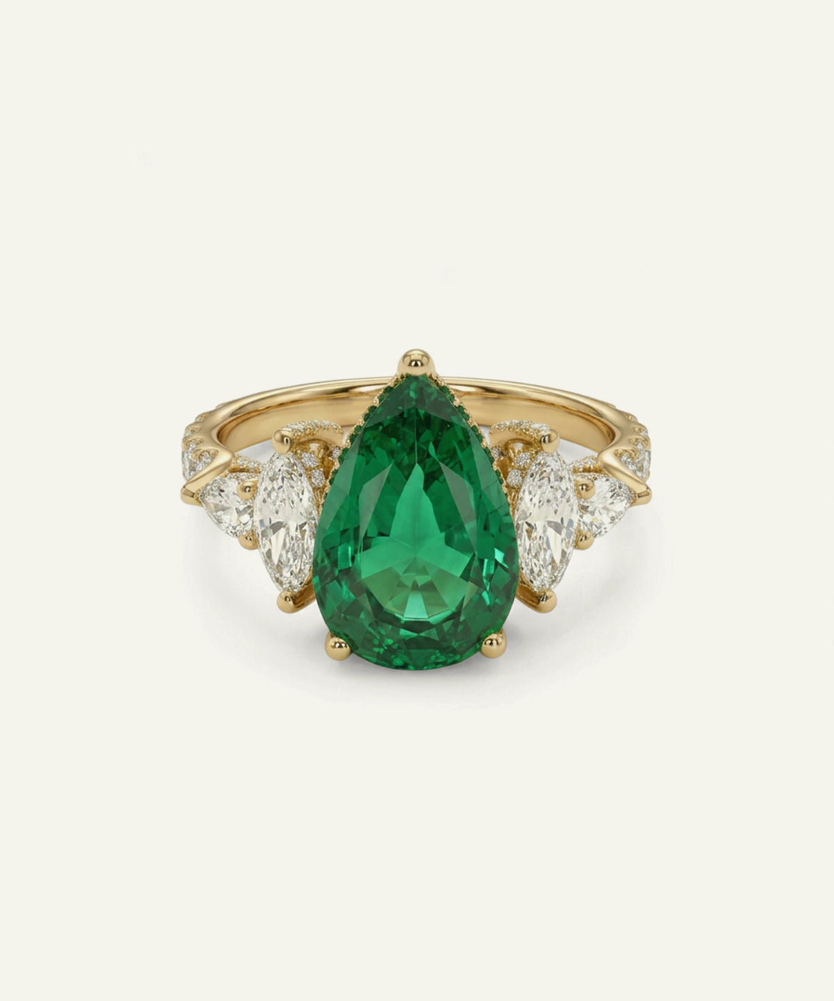 A yellow gold ring featuring a large pear-cut green emerald center stone, flanked by marquise-cut clear diamonds on a light cream background.