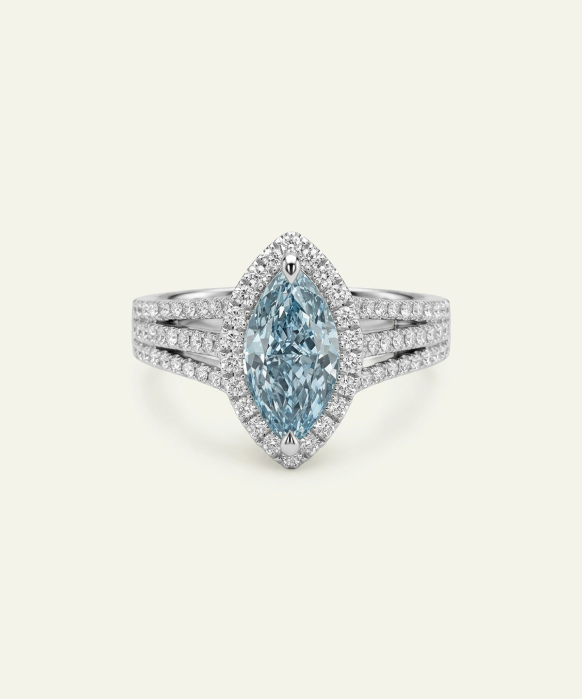 A luxury silver-tone ring featuring a marquise-cut light blue gemstone in a halo setting, with a split shank paved with small round stones, shown on a light cream background.