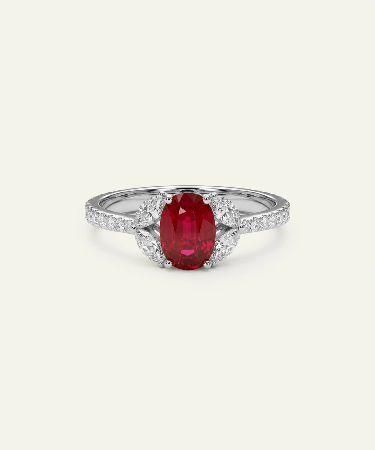 An oval-cut red ruby ring set in a silver-colored metal with pavé diamond accents on the band, centered on a light cream background.