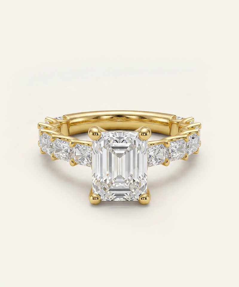 Gold ring with a large diamond and smaller diamonds on the sides against a light background