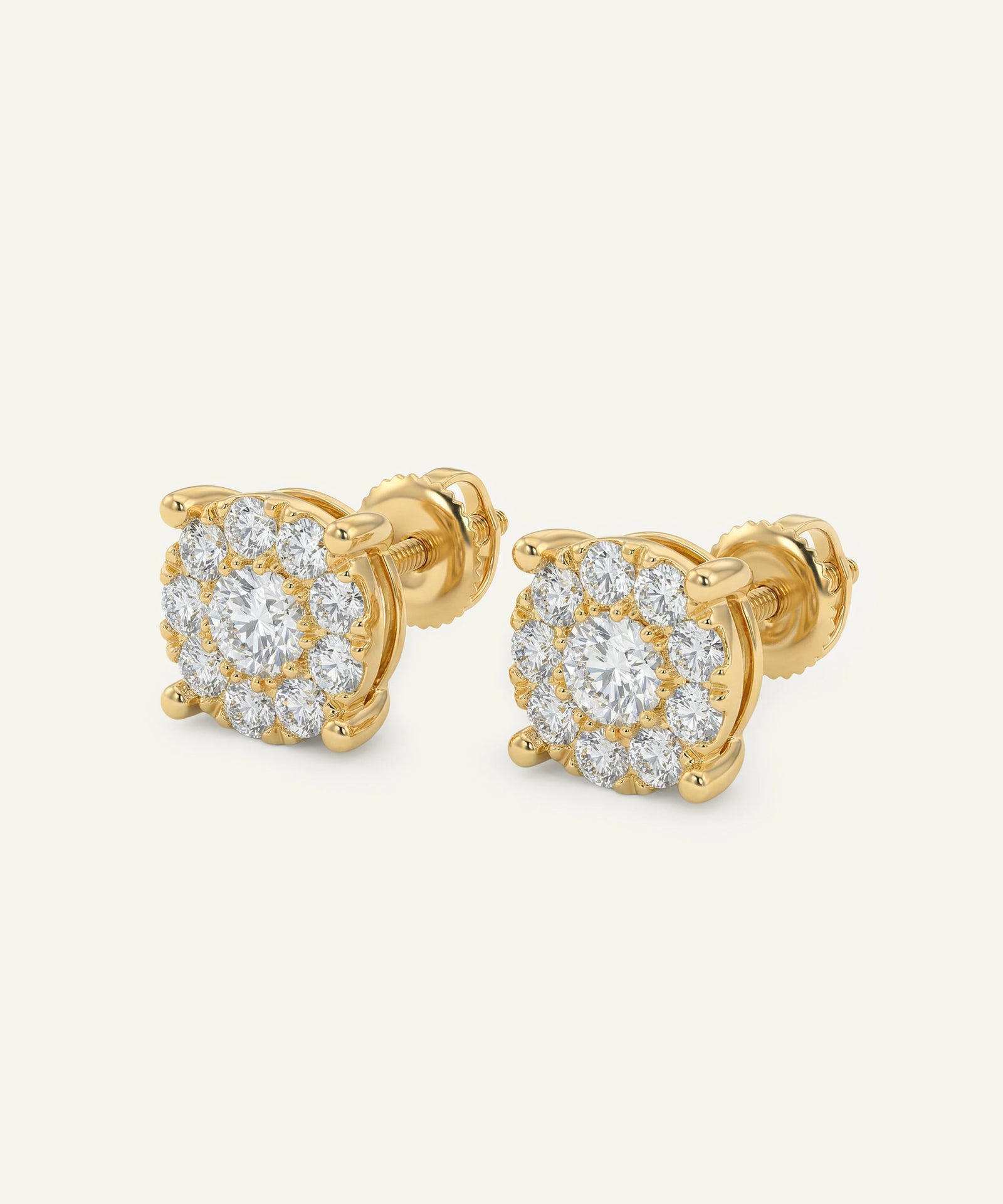 Gold earrings with diamond accents on a light beige background