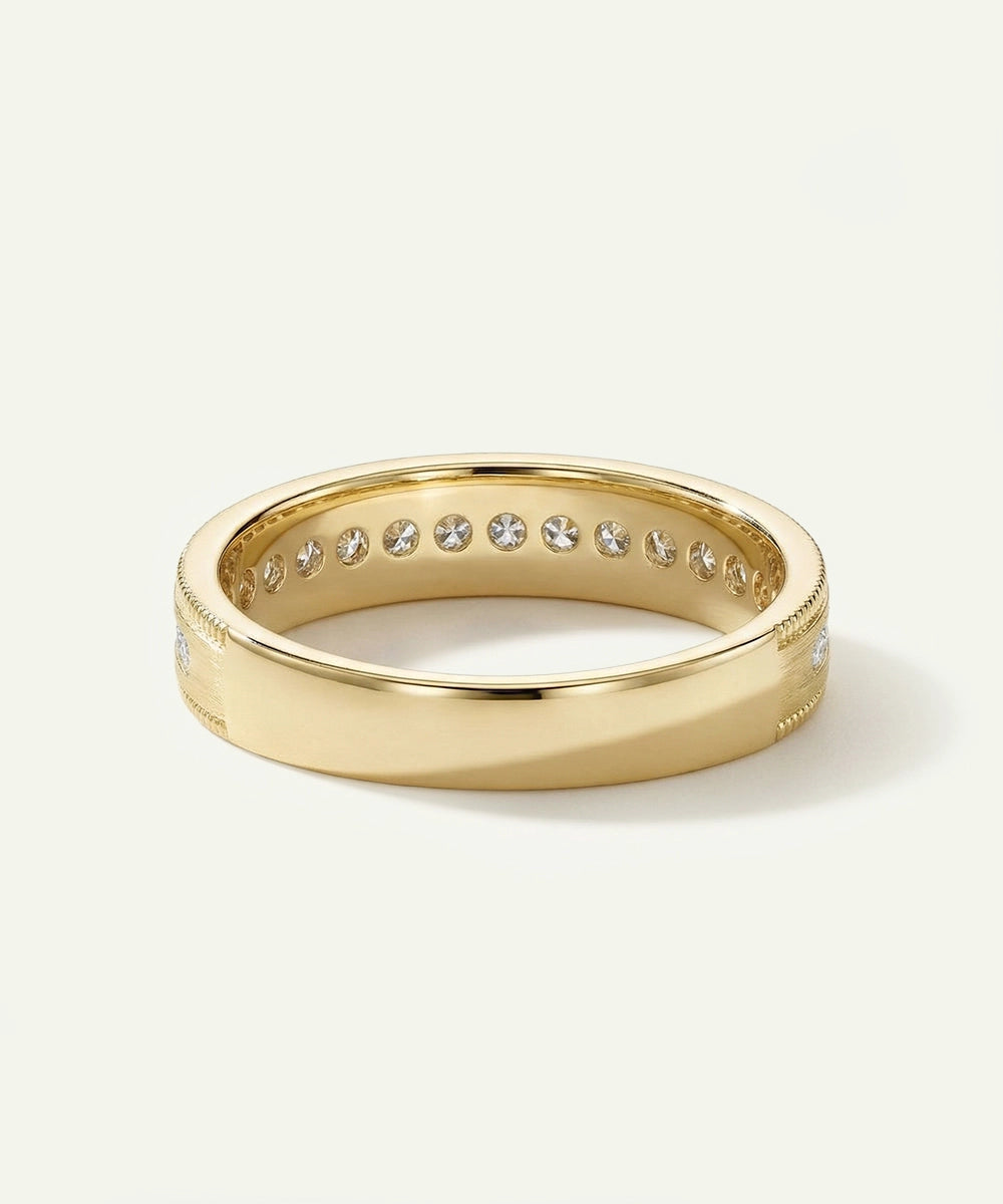 Gold ring with embedded diamonds on a light beige background