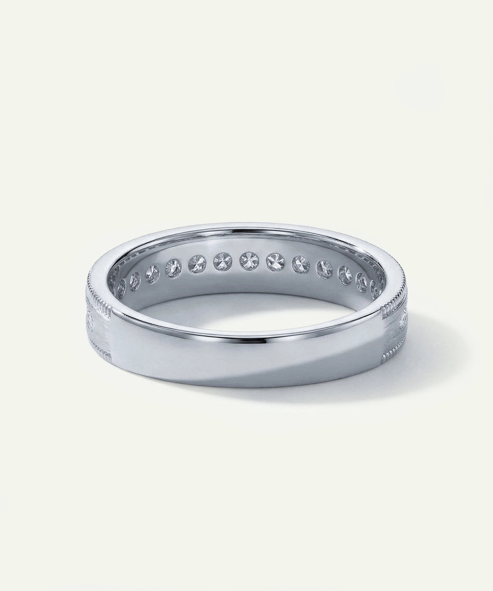 Silver ring with small diamonds on a light gray background