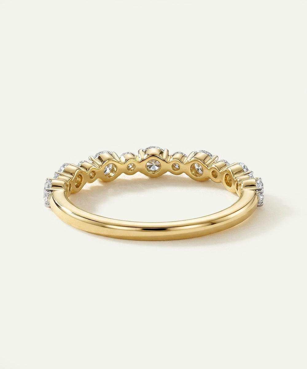 Gold ring with small diamonds on a light beige background