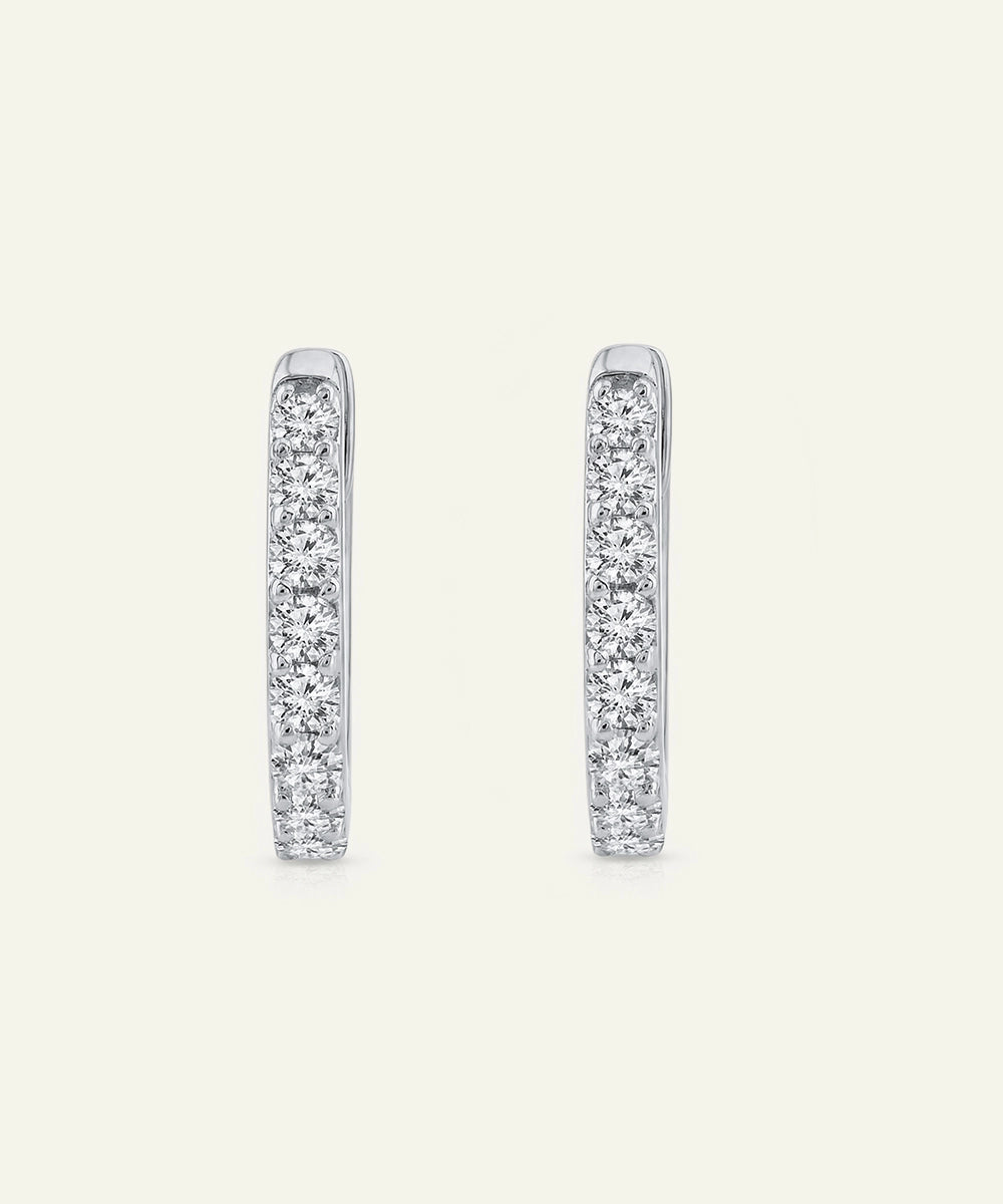 Pair of diamond hoop earrings on a light gray background