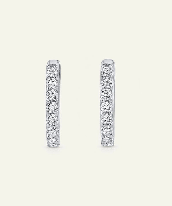 Pair of diamond hoop earrings on a light gray background
