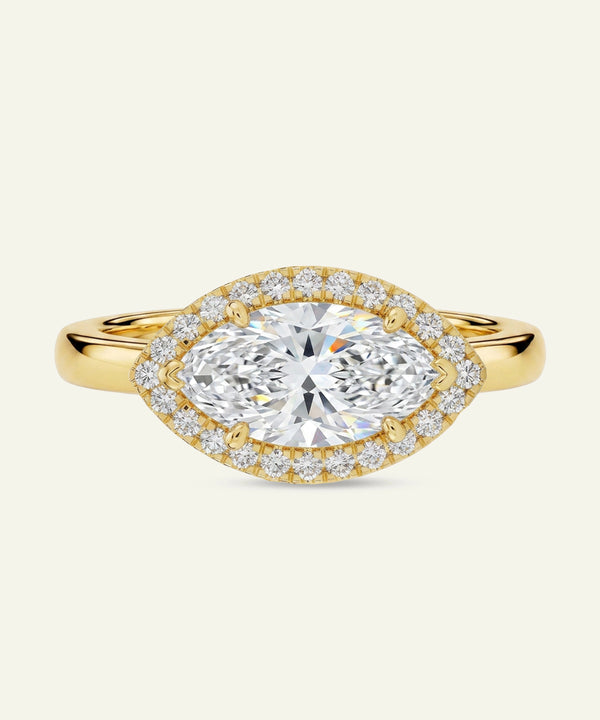 Gold ring with a large diamond and smaller diamonds around on a white background