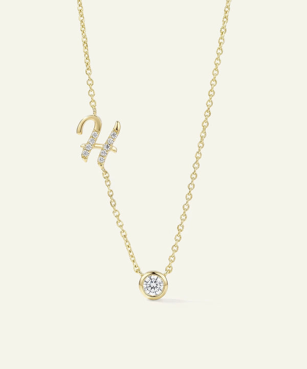 Gold necklace with a small round pendant on a light beige background